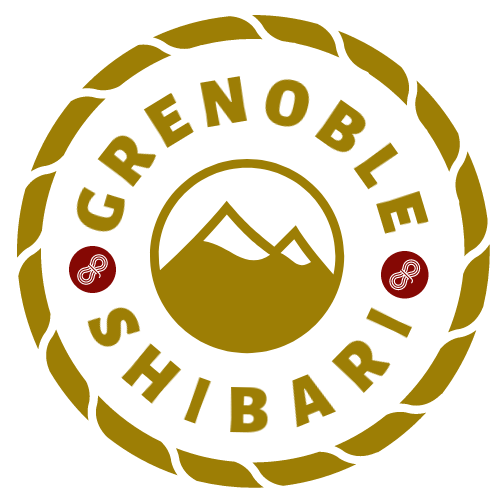 Logo jaune foncé sur fond blanc en flat-design de montagnes entourées du texte Shibari Grenoble, le tout entouré d'une corde